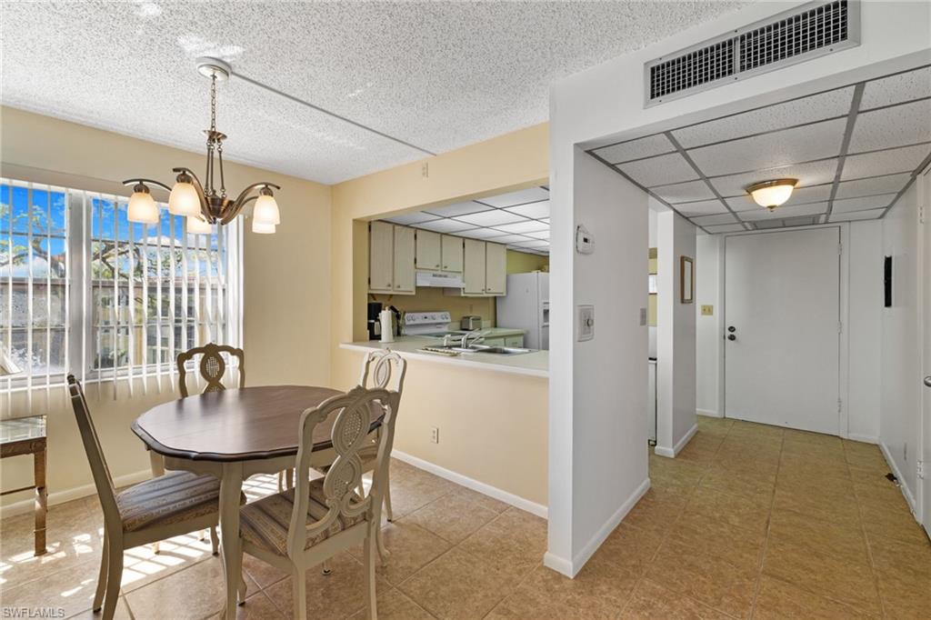 Dining space with a chandelier, light tile patterned floors, and a textured ceiling