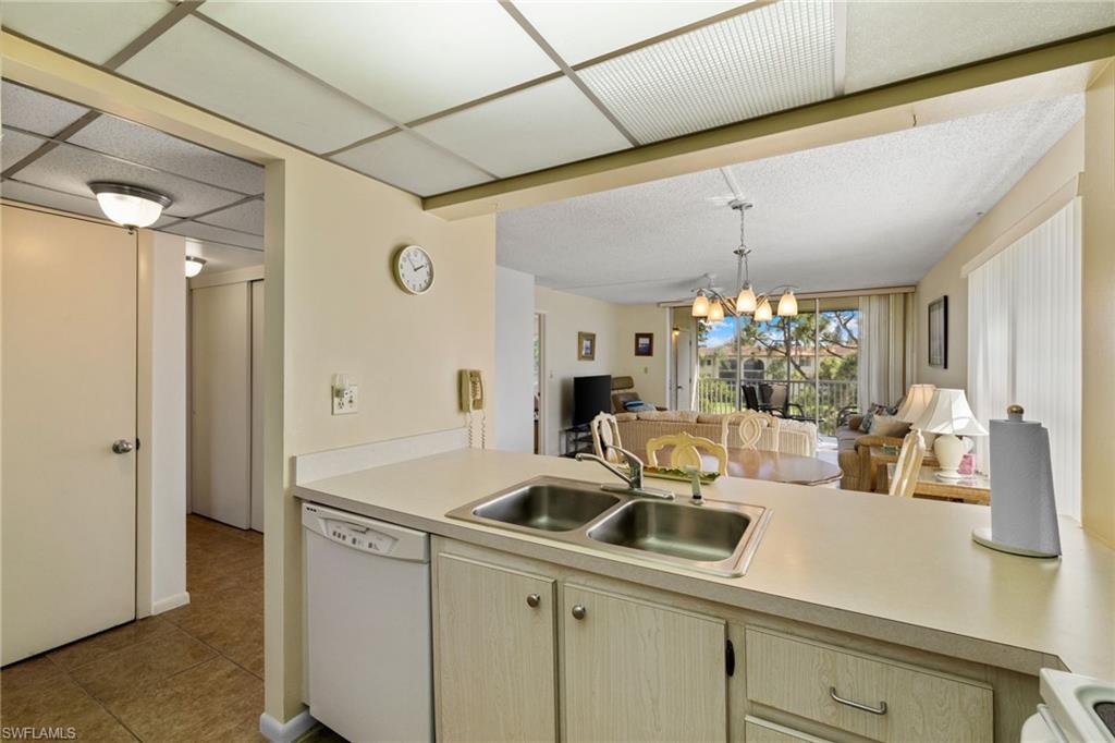 Kitchen with open floor plan, a chandelier, light countertops, and white appliances