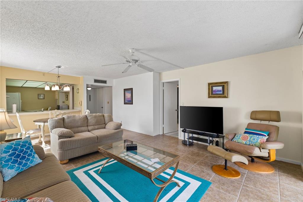 Tiled living room featuring a textured ceiling and a ceiling fan