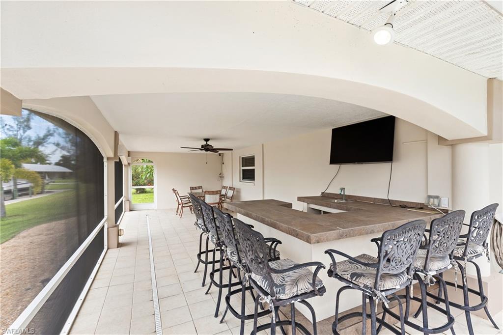 View of patio / terrace featuring a sunroom and a ceiling fan