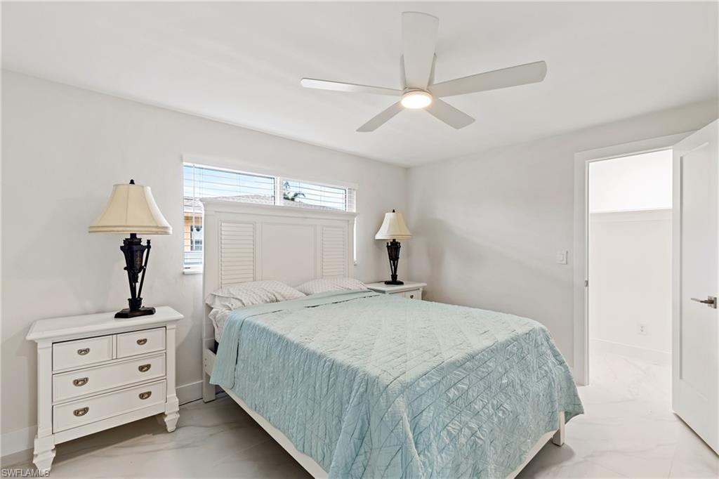 Bedroom with light marble finish floors and ceiling fan