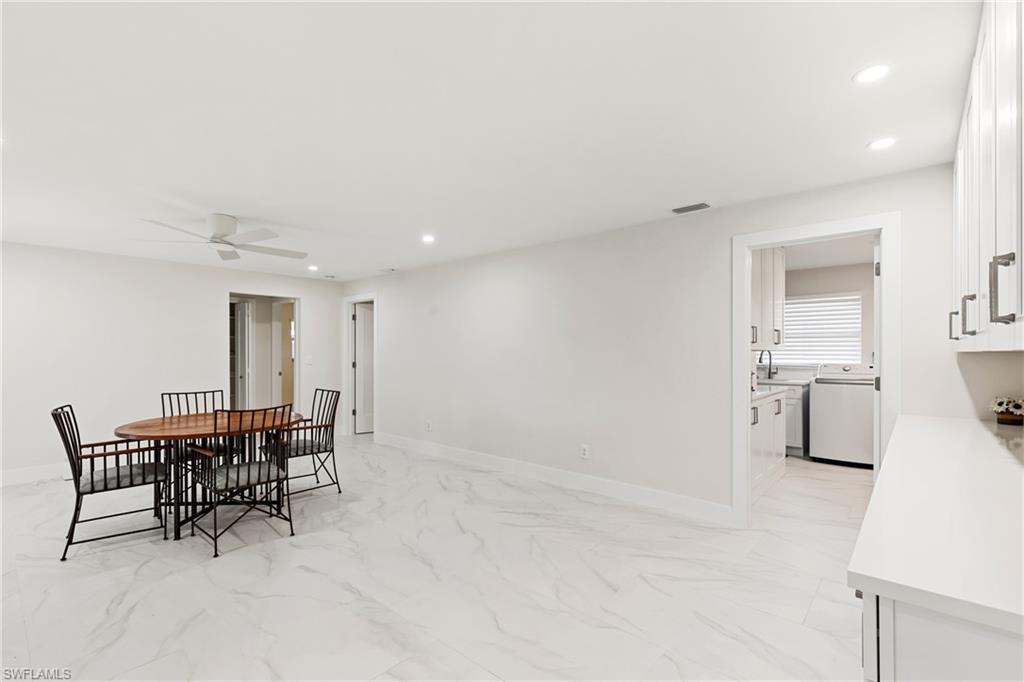 Dining space featuring recessed lighting, light marble finish floors, washer / dryer, and a ceiling fan