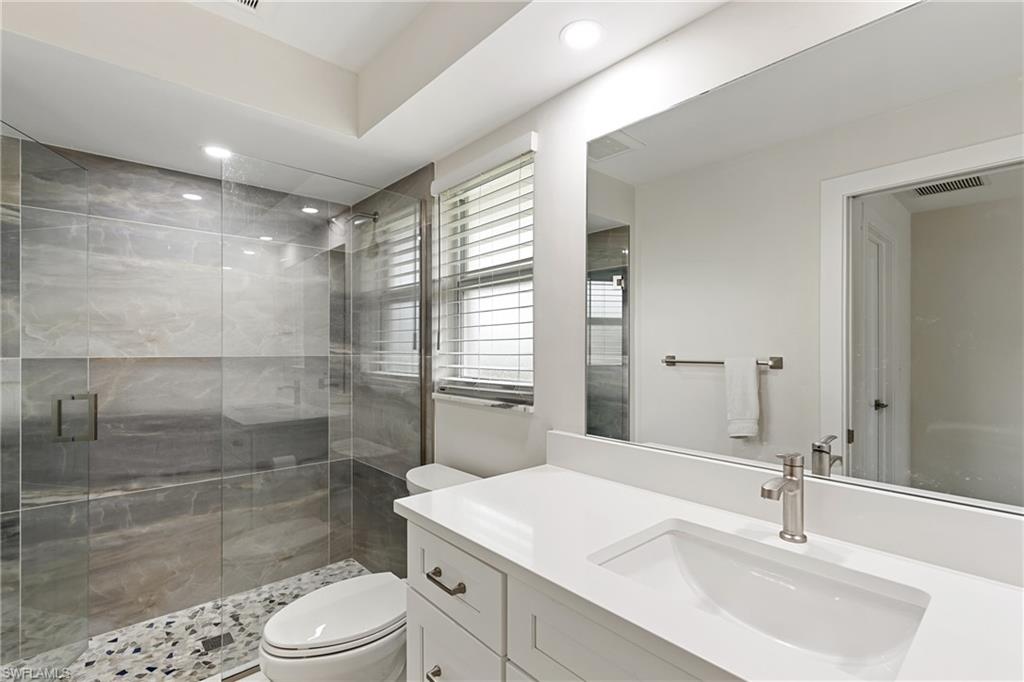 Full bathroom featuring a stall shower, vanity, and recessed lighting