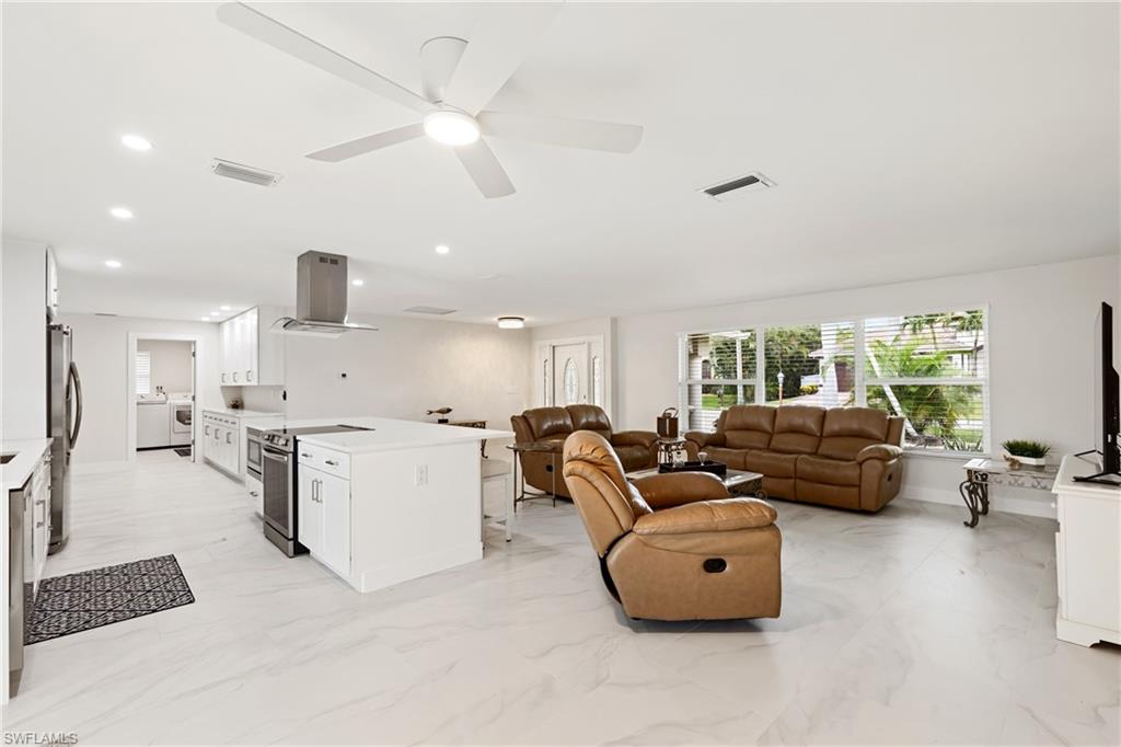Living room featuring light marble finish floors, recessed lighting, ceiling fan, and washer / clothes dryer