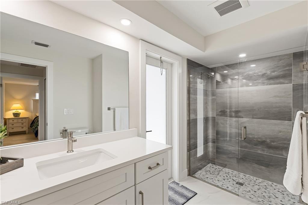 Full bath with a stall shower, vanity, and recessed lighting