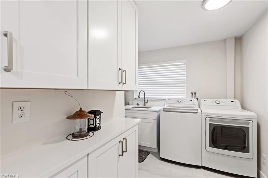 Washroom featuring cabinet space and independent washer and dryer