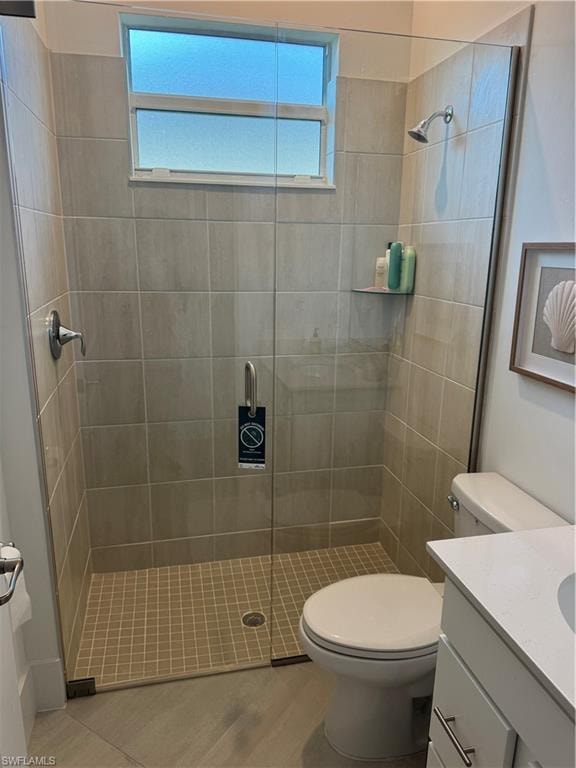 Bathroom featuring vanity, toilet, walk in shower, and a wealth of natural light