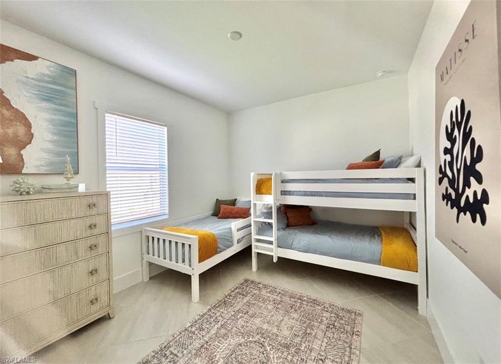 Bedroom with light tile patterned flooring and baseboards