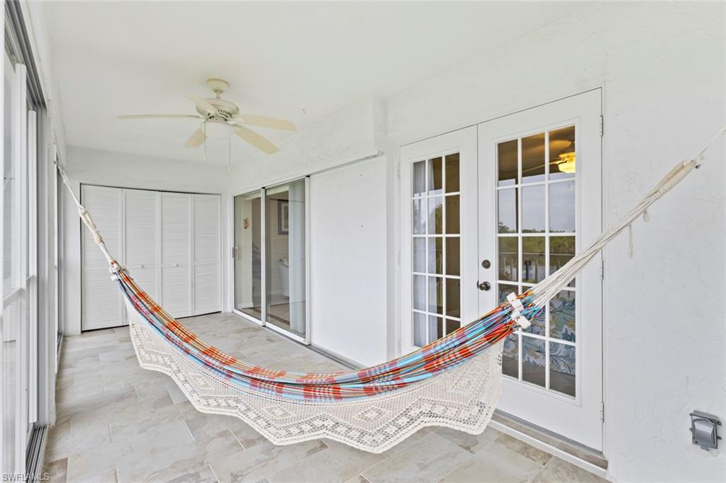 Unfurnished sunroom with ceiling fan and a patio area