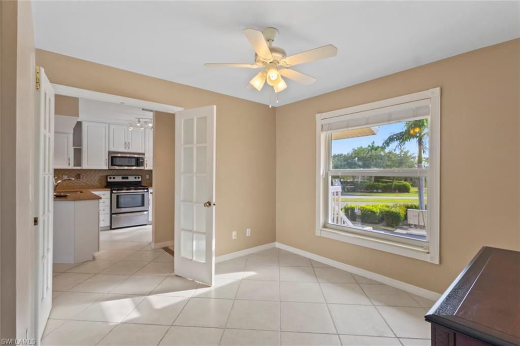 Unfurnished dining area featuring light tile patterned flooring, ceiling fan, and french doors