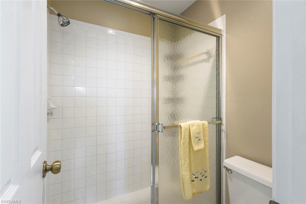 Full bath featuring a stall shower and toilet