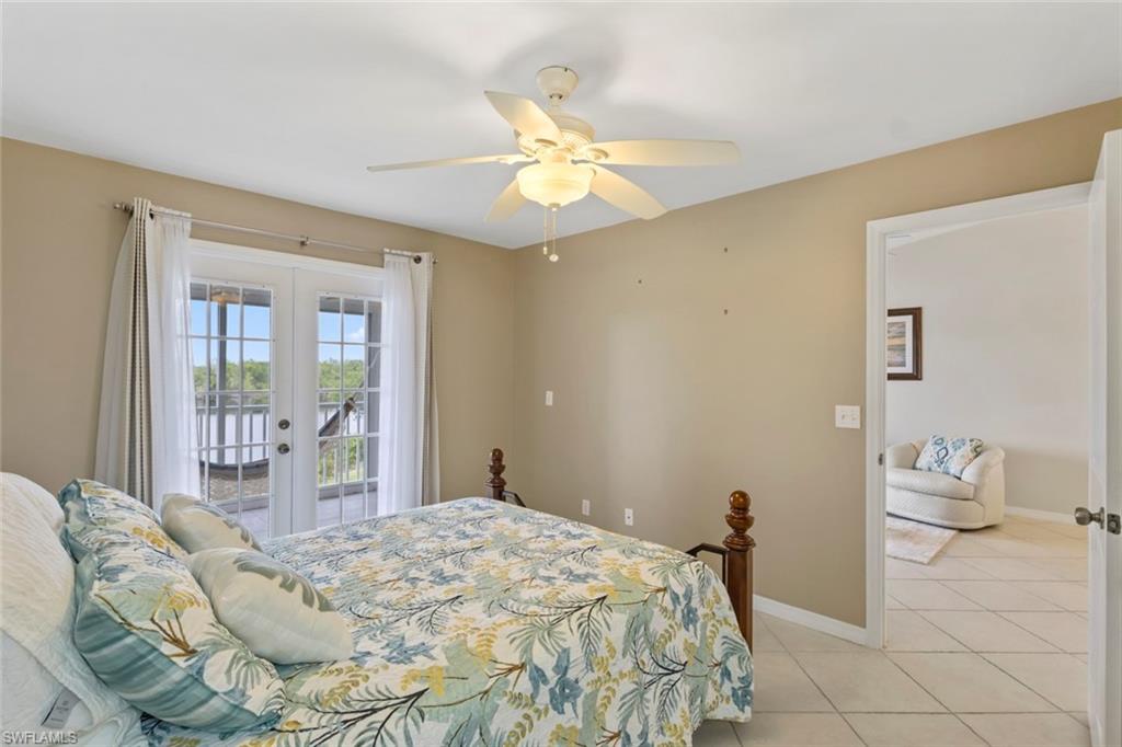 Bedroom with french doors, access to exterior, light tile patterned floors, and ceiling fan
