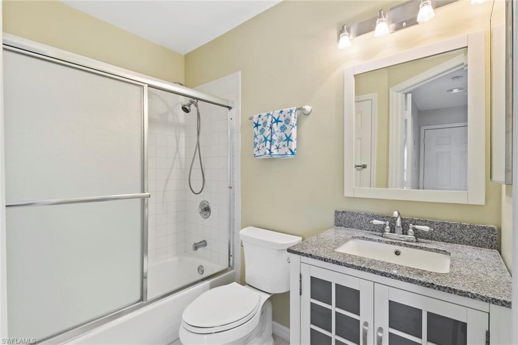 Bathroom with shower / bath combination with glass door and vanity