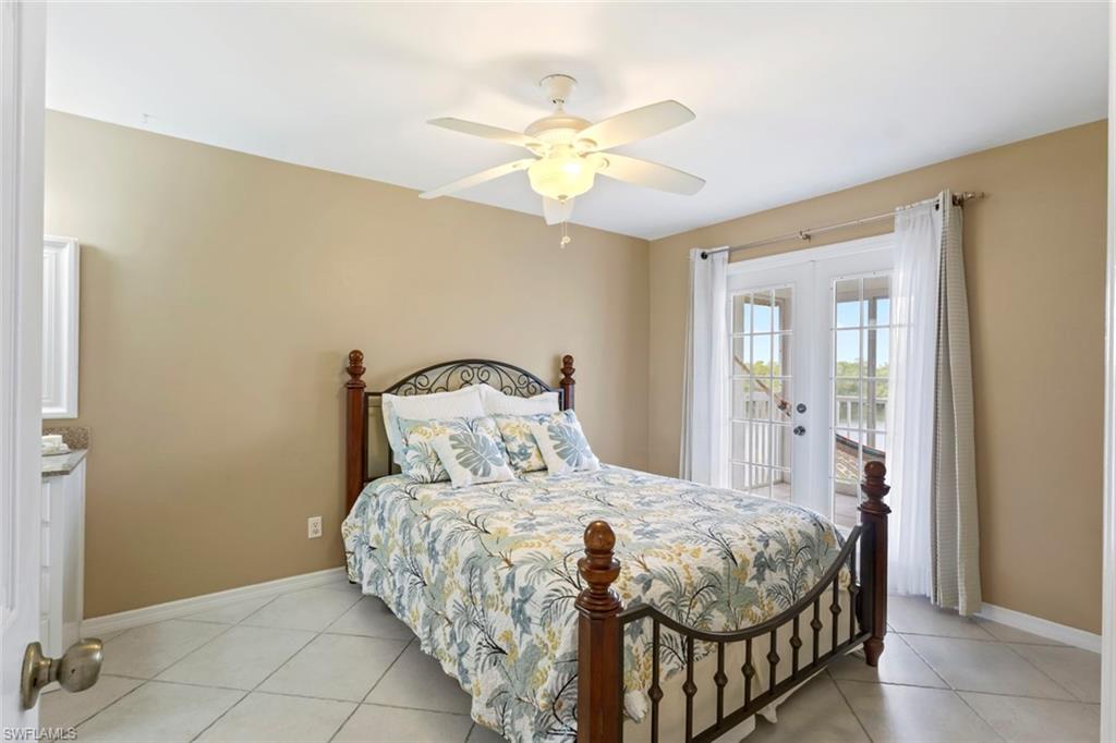 Bedroom with french doors, light tile patterned floors, access to exterior, and a ceiling fan