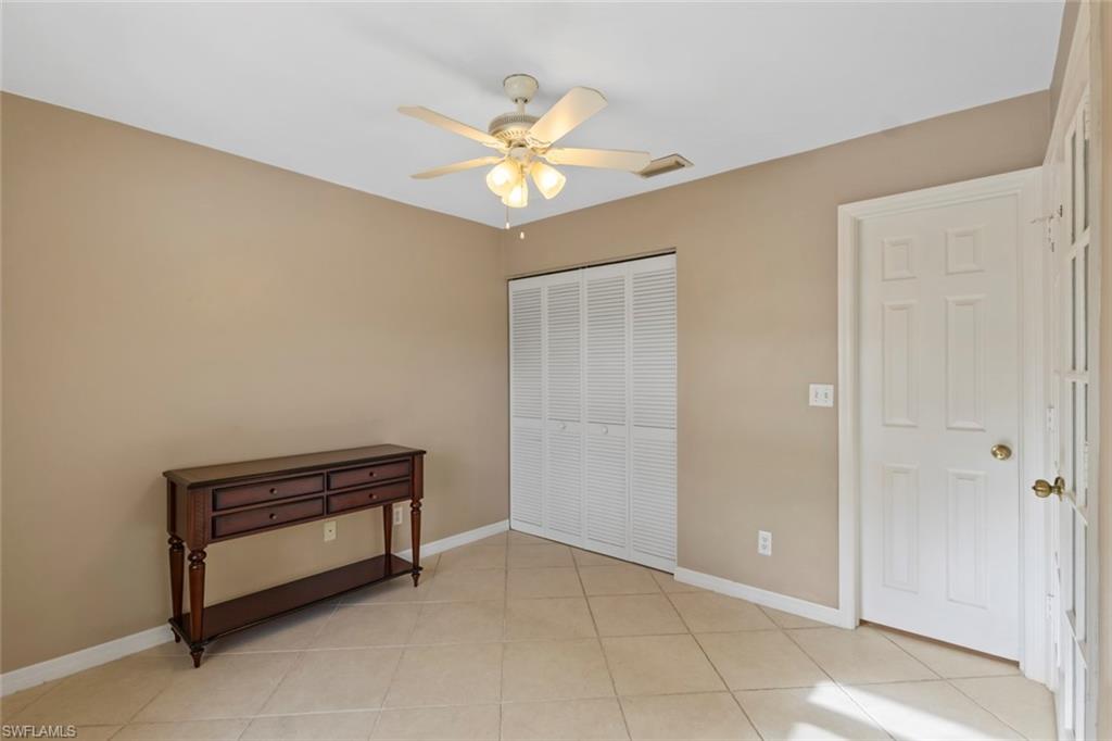 Bedroom with a closet, light tile patterned flooring, and ceiling fan