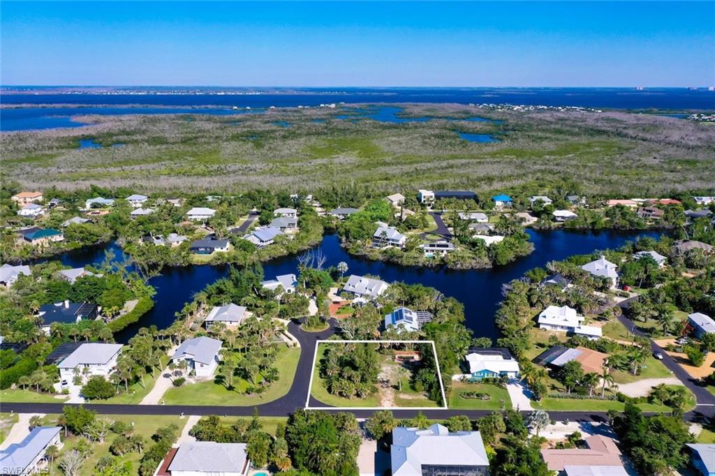 Aerial overview of property's location featuring property parcel outlined, a nearby body of water, and nearby suburban area