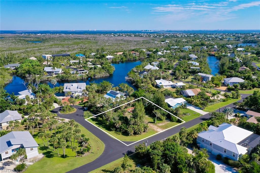 Aerial view of residential area featuring property parcel outlined and a nearby body of water
