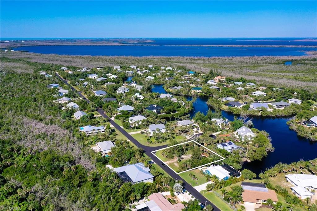 Aerial view of property and surrounding area with a nearby body of water and nearby suburban area