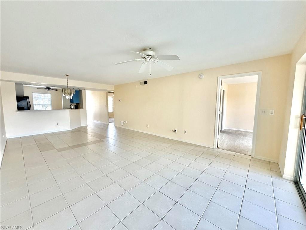 Spacious room featuring tile flooring, a ceiling fan, and light-toned walls
