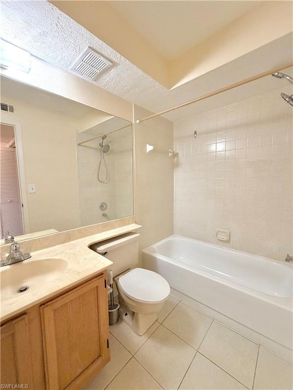 Bathroom featuring a wood-finish vanity with a single basin sink and a light-toned countertop, a full-size bathtub with a shower, ceramic tile flooring, and a large wall-mounted mirror