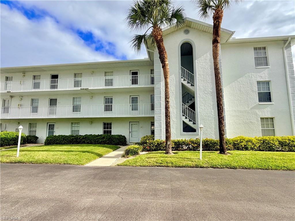Multi-story building featuring white stucco exterior and multiple balconies