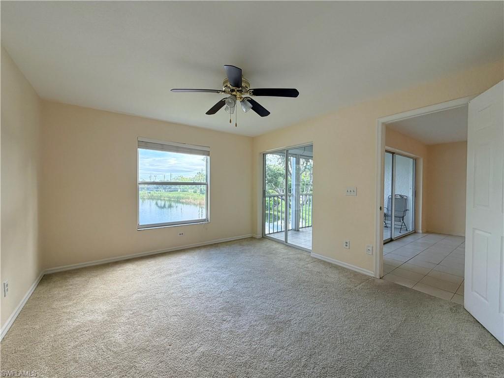 Spacious room featuring carpet flooring, a ceiling fan, and ample natural light from a large window