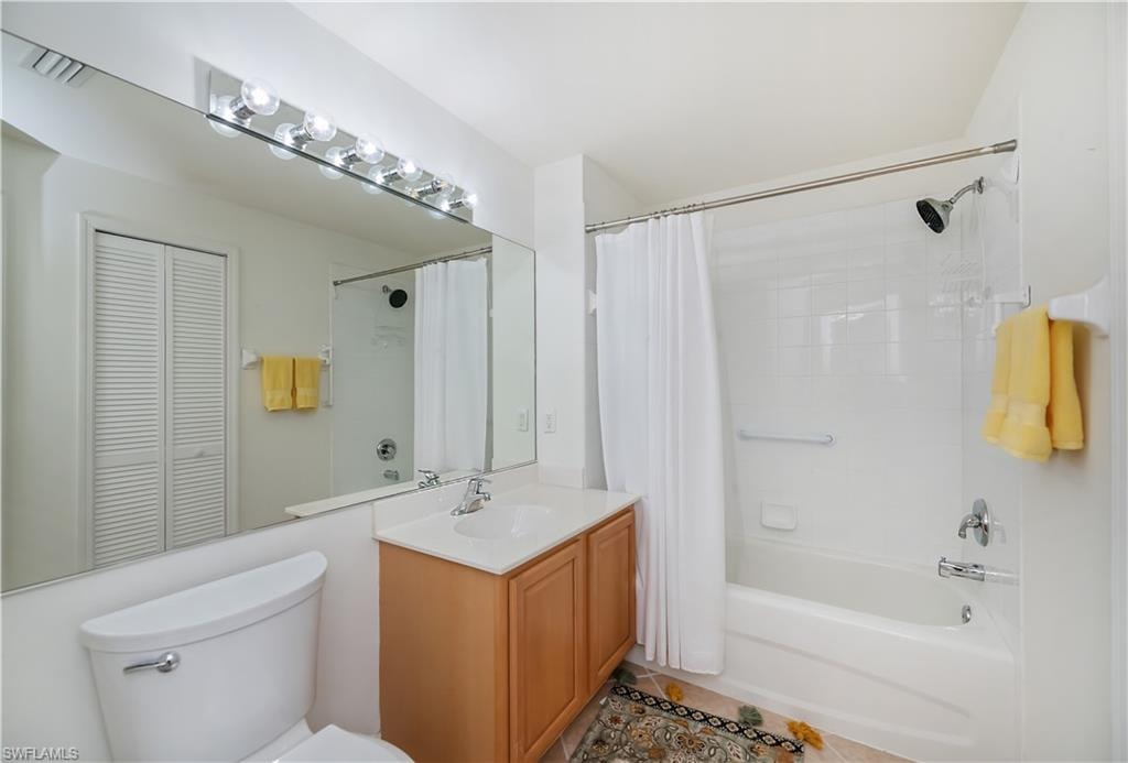 Bathroom with vanity, a closet, shower / bath combination with curtain, and tile patterned flooring