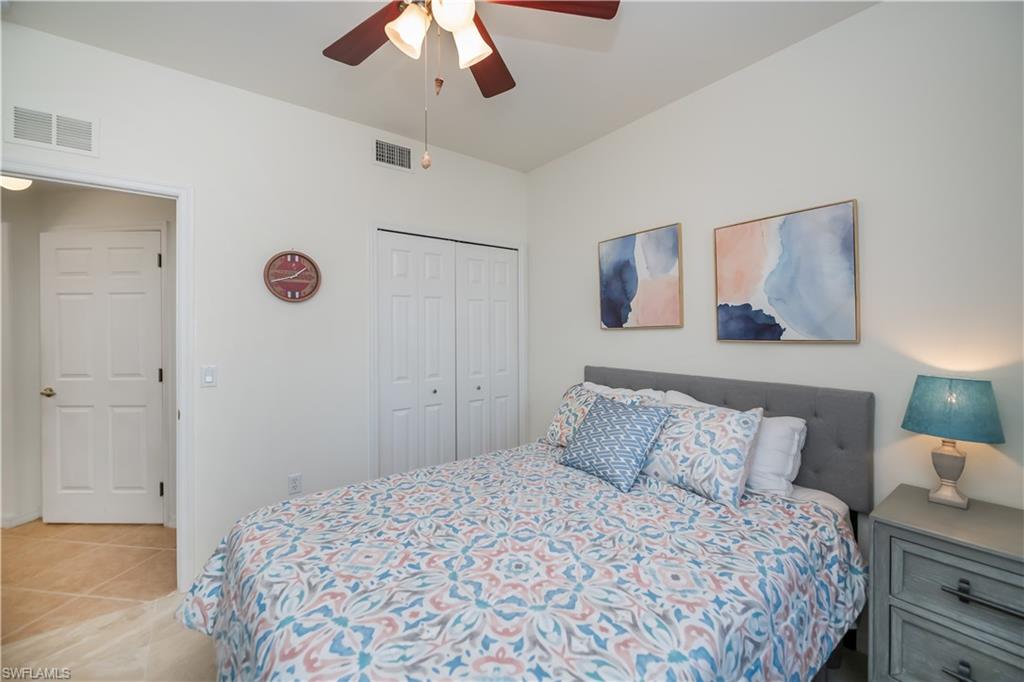 Bedroom with light tile patterned floors, a ceiling fan, and a closet