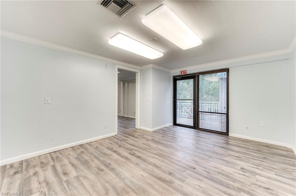 Empty room with ornamental molding and light wood-style flooring