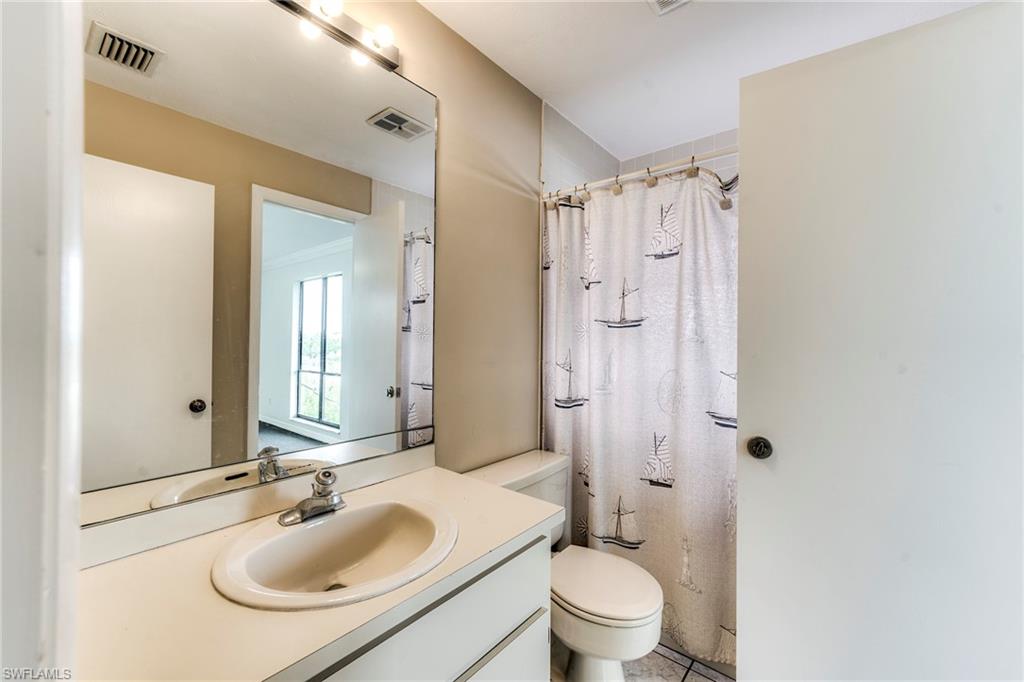 Full bath with curtained shower and vanity