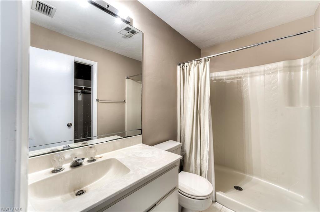 Full bathroom with a shower stall, vanity, and a textured ceiling