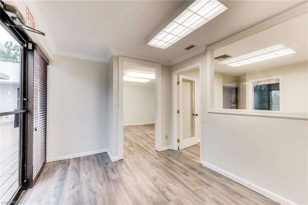 Empty room featuring light wood-type flooring and ornamental molding