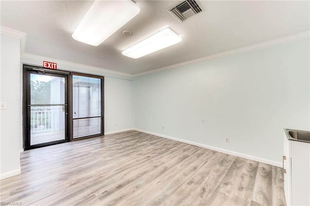 Empty room with ornamental molding and light wood-style flooring