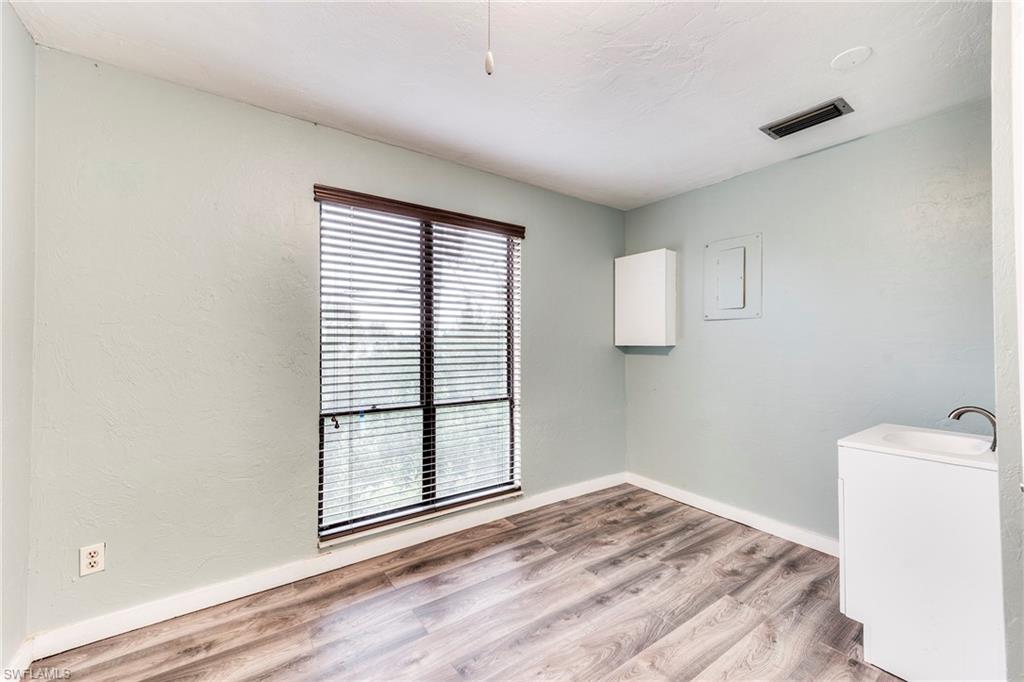 Unfurnished room featuring light wood finished floors and a textured wall