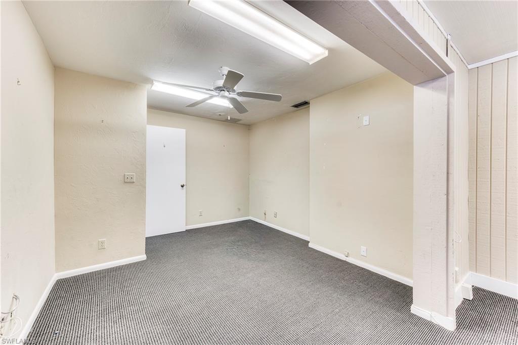 Carpeted spare room with a ceiling fan and baseboards