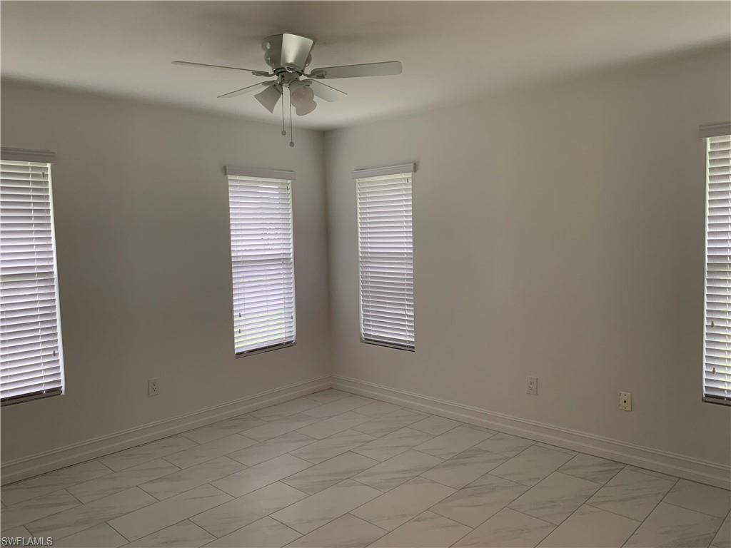 Unfurnished room with a ceiling fan baseboards