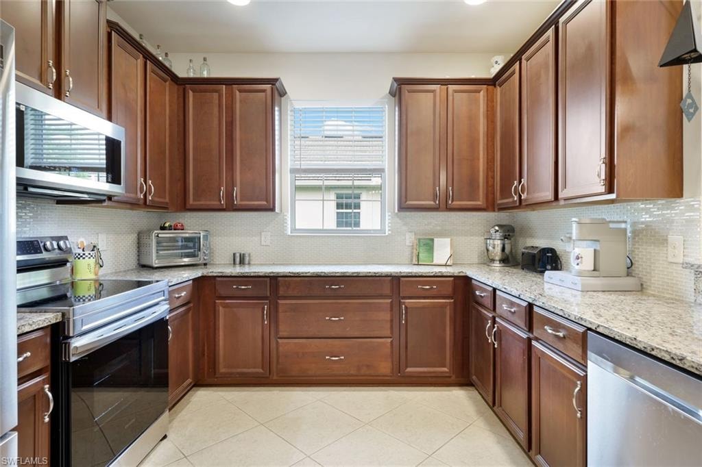 Living room with light tile patterned floors, ceiling fan, a tray ceiling, and recessed lighting