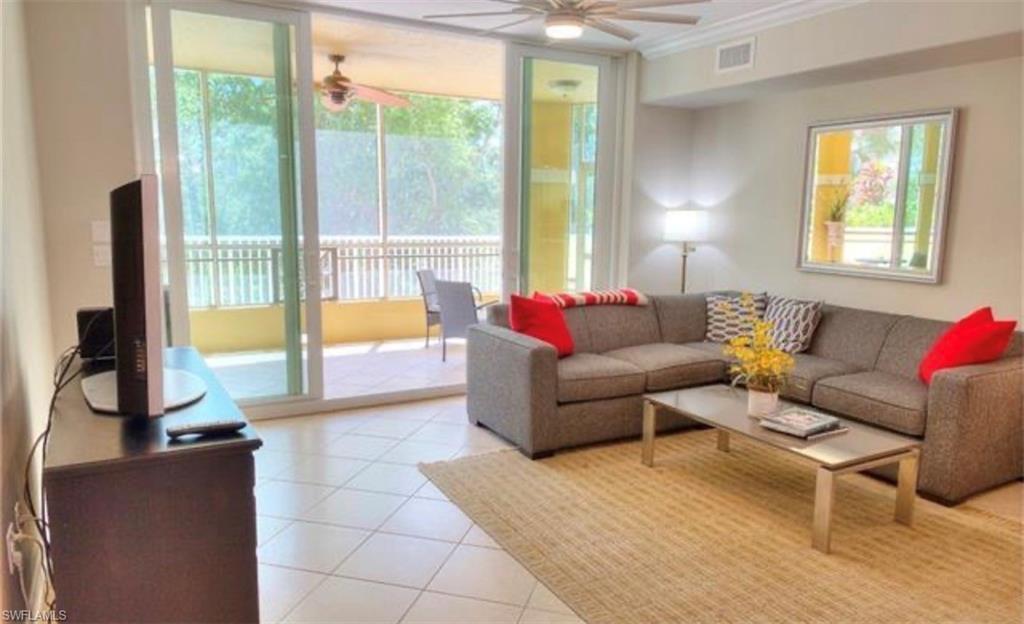 Tiled living room featuring healthy amount of natural light, crown molding, and ceiling fan