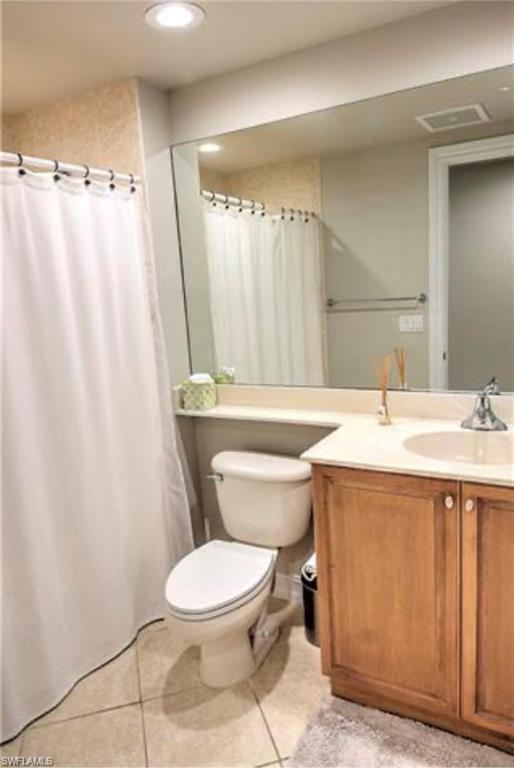 Full bathroom featuring light tile patterned floors, vanity, curtained shower, and recessed lighting