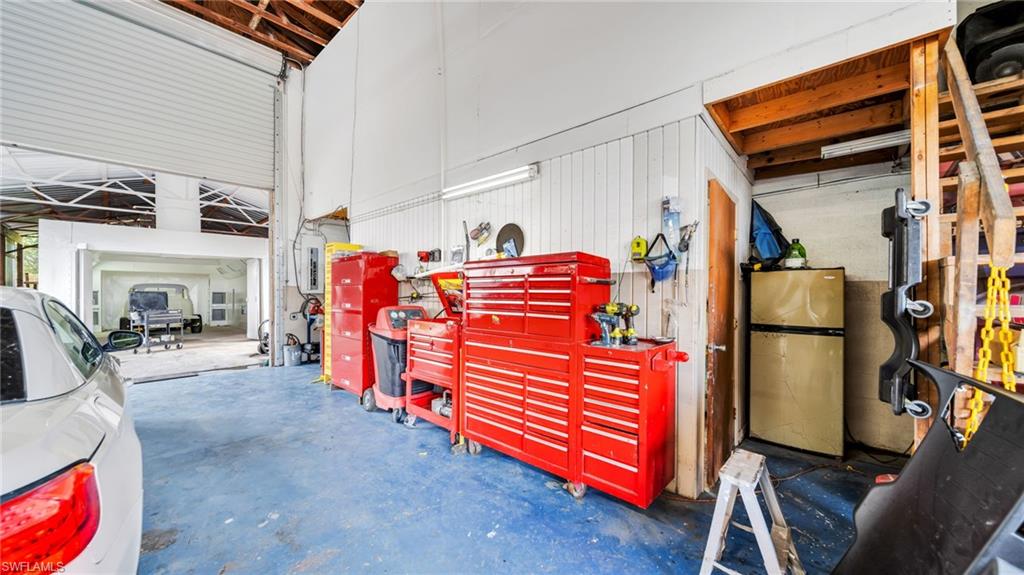 Garage featuring freestanding refrigerator and electric panel