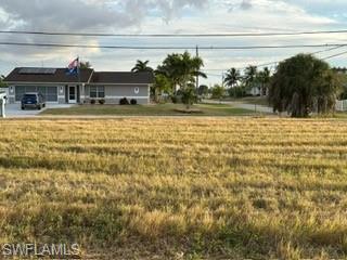 View of front of property featuring a front lawn and a rural view