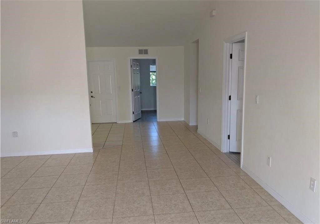 Spare room featuring light tile patterned floors and baseboards