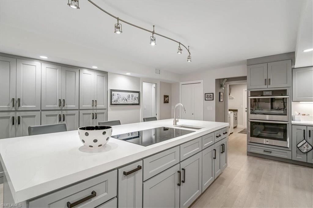 Kitchen featuring gray cabinetry, double oven, recessed lighting, black electric stovetop, and light wood-style flooring