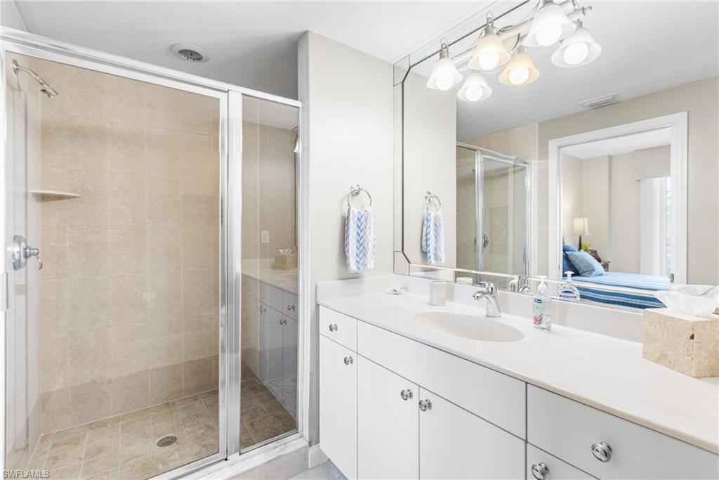 The second full ensuite bath offers a private, well-appointed retreat featuring a walk-in shower finished with floor-to-ceiling porcelain tile and a sleek single vanity. Designed for comfort and privacy, it serves as an elegant extension of the second bedroom, providing a refined and self-contained guest suite experience.