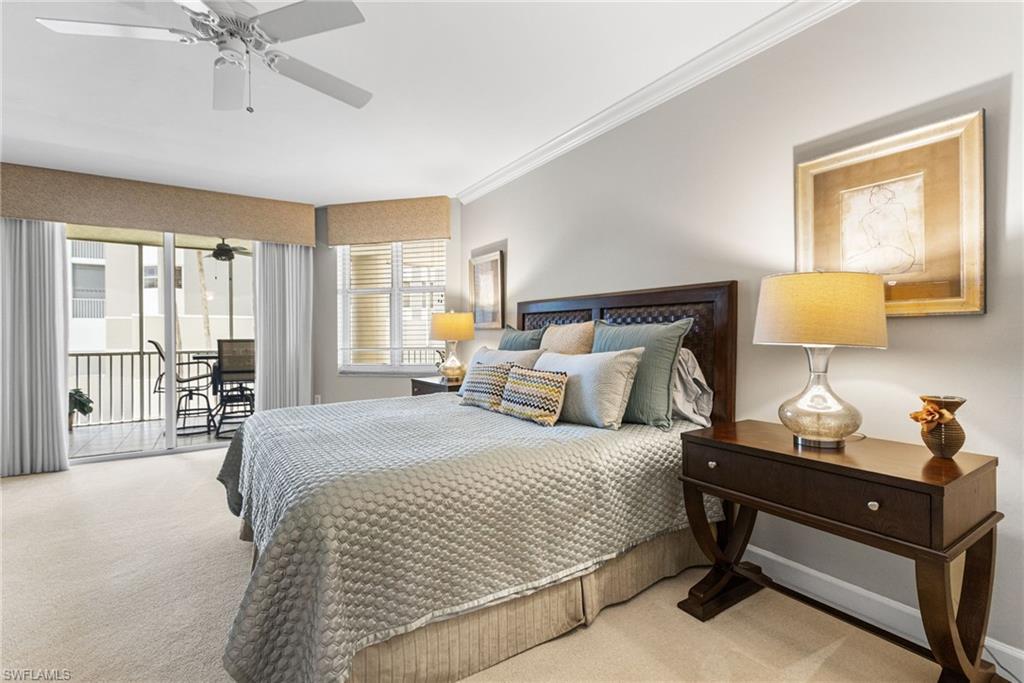 Your primary bedroom is generously proportioned, offering an oversized layout designed for both comfort and sophistication. Expansive sliding glass doors provide direct access to the lanai, inviting in abundant natural light and creating a seamless indoor-outdoor connection. Soft carpeting underfoot adds warmth and comfort, enhancing the serene and restful ambiance of this private retreat.