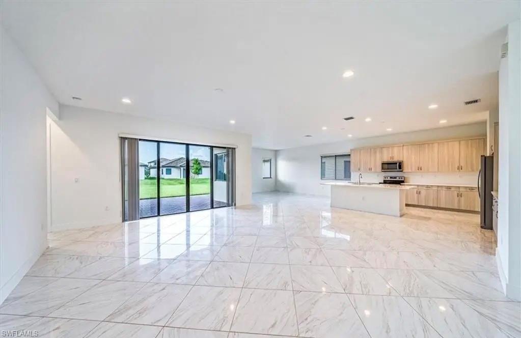 Unfurnished living room with recessed lighting and light marble finish flooring