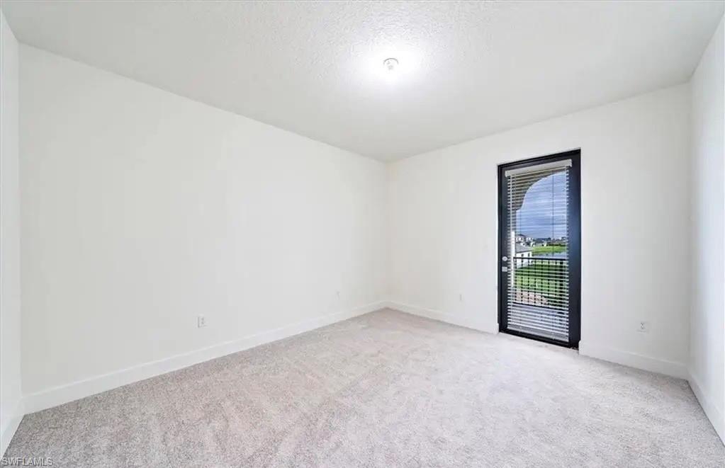 Unfurnished room featuring light carpet and a textured ceiling