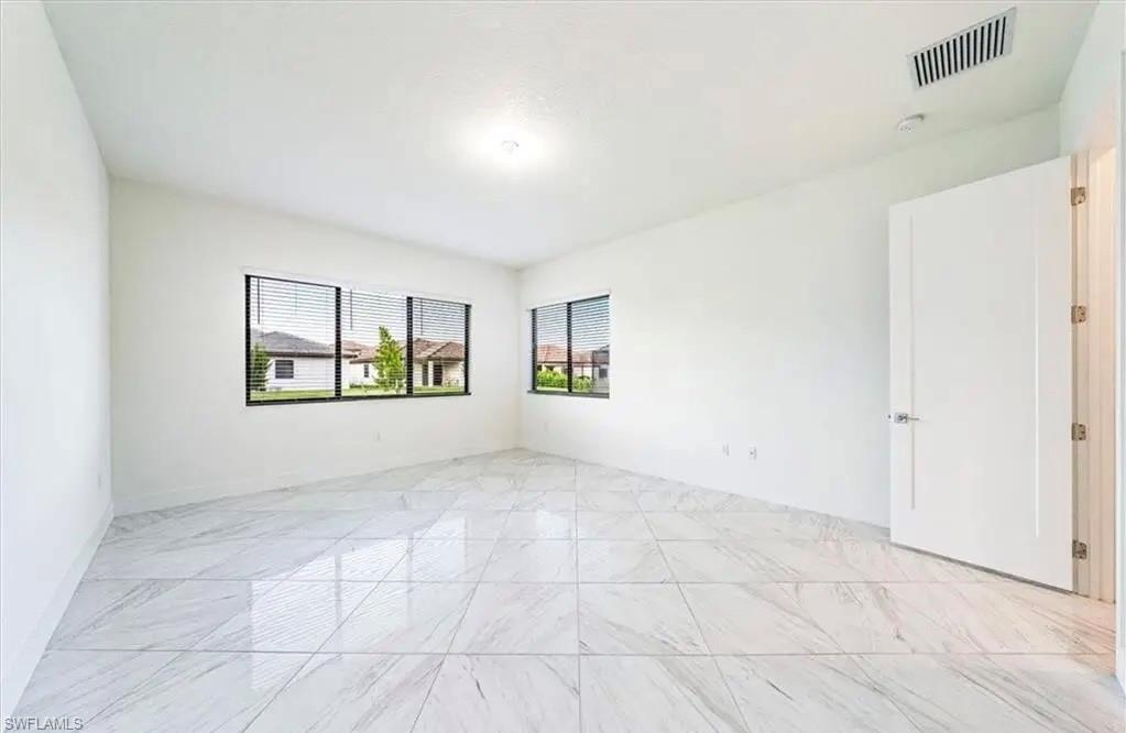 Spare room featuring light marble finish floors