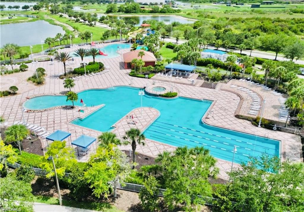 Community pool with a hot tub, a water view, and a patio area