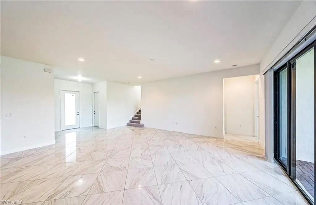 Spare room with recessed lighting, stairs, and light marble finish flooring